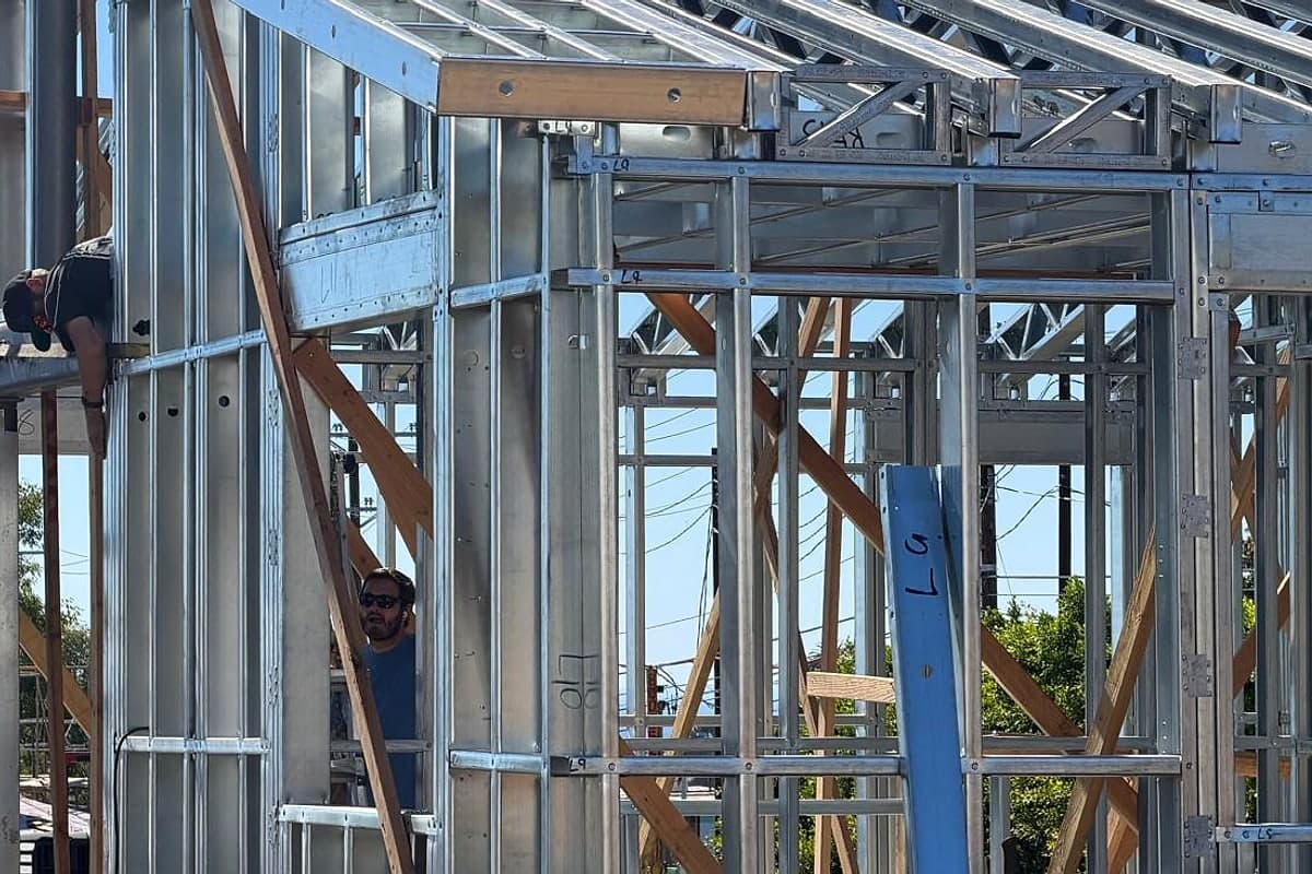 Framers working in the steel frame under the roof framing