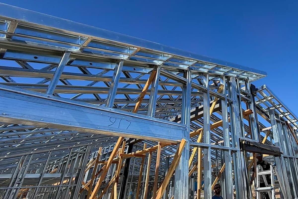 Light-gauge steel eave and wall framing held by temporary wood braces