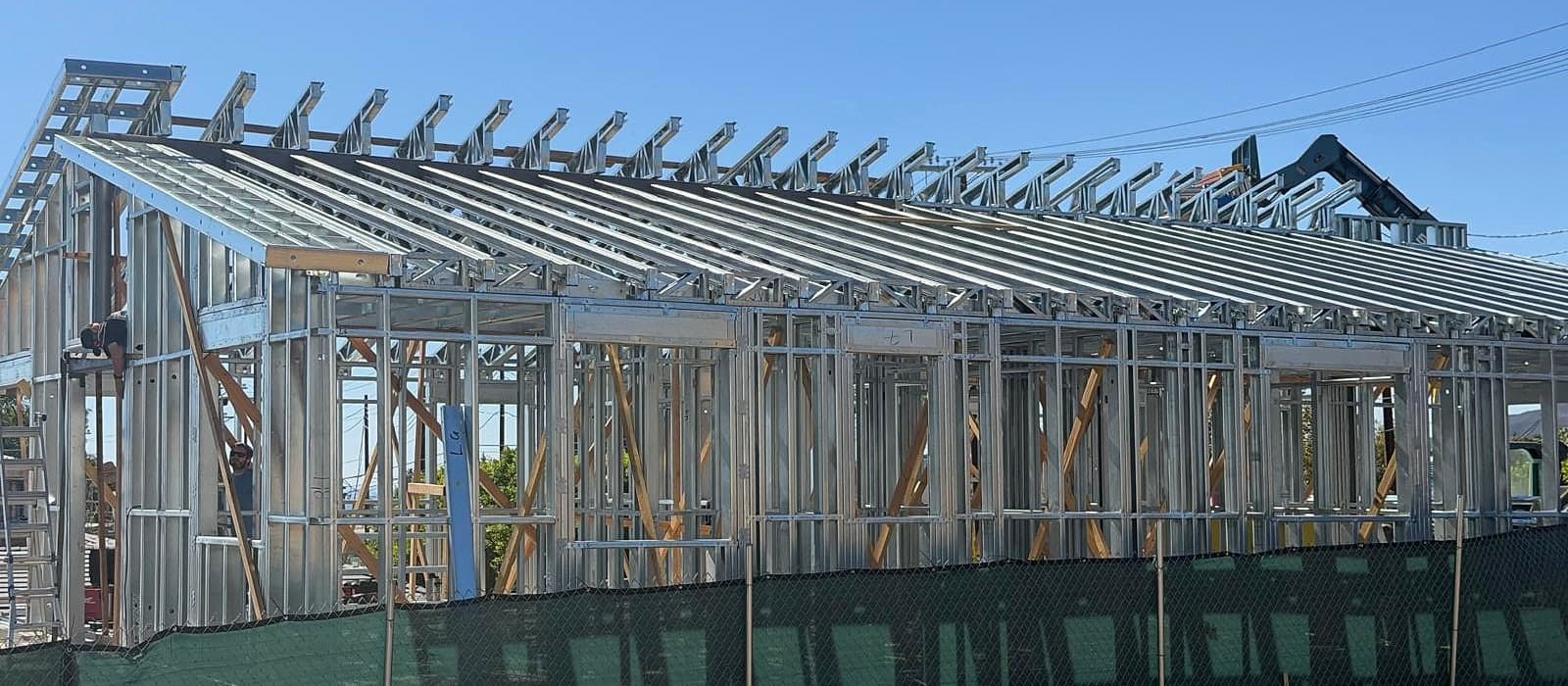 Job-site photo of the same house in Pacific Palisades framed in light-gauge steel, with the roof framing complete