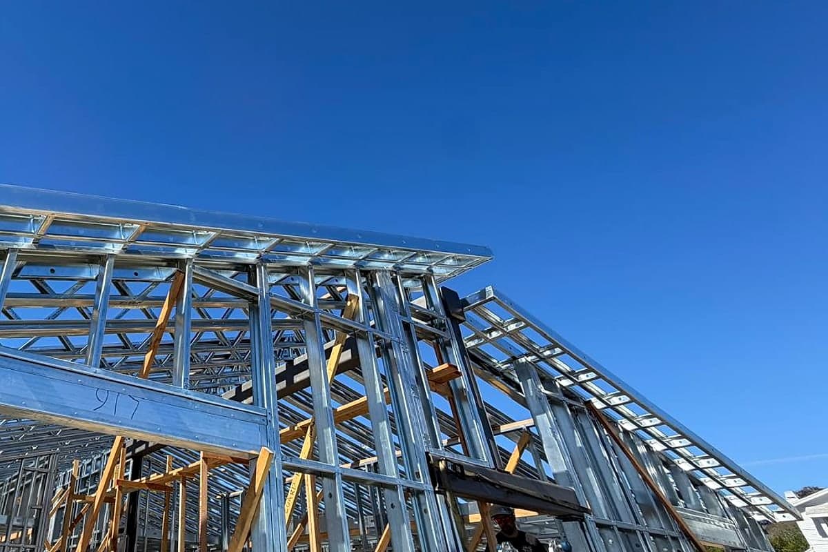 The steel roof plane and braced walls against a deep blue sky