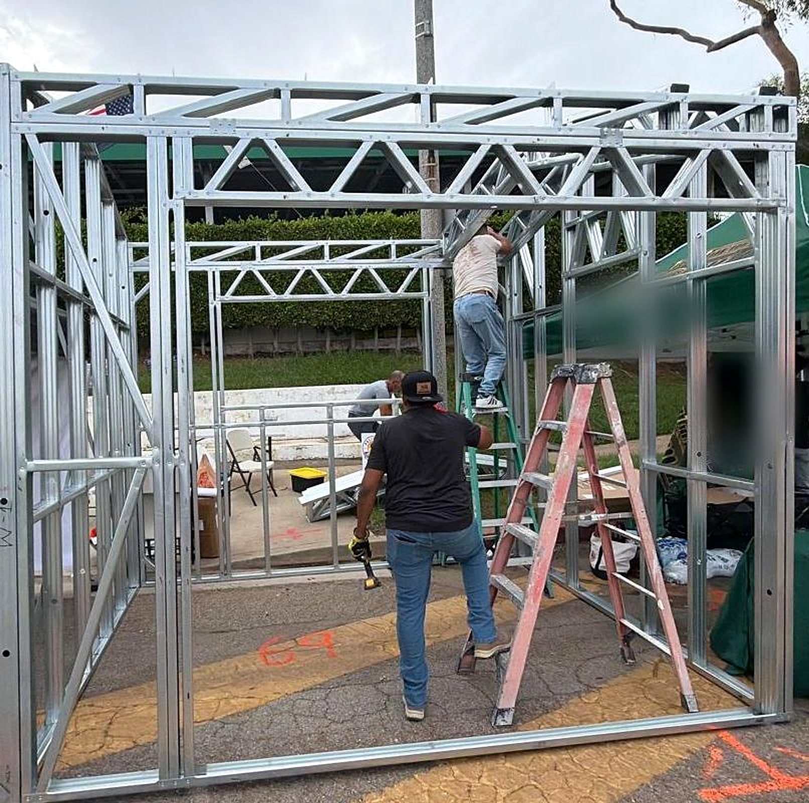 Assembling a steel frame display Assembling a full-size light-gauge steel frame display with roof trusses at an outdoor expo